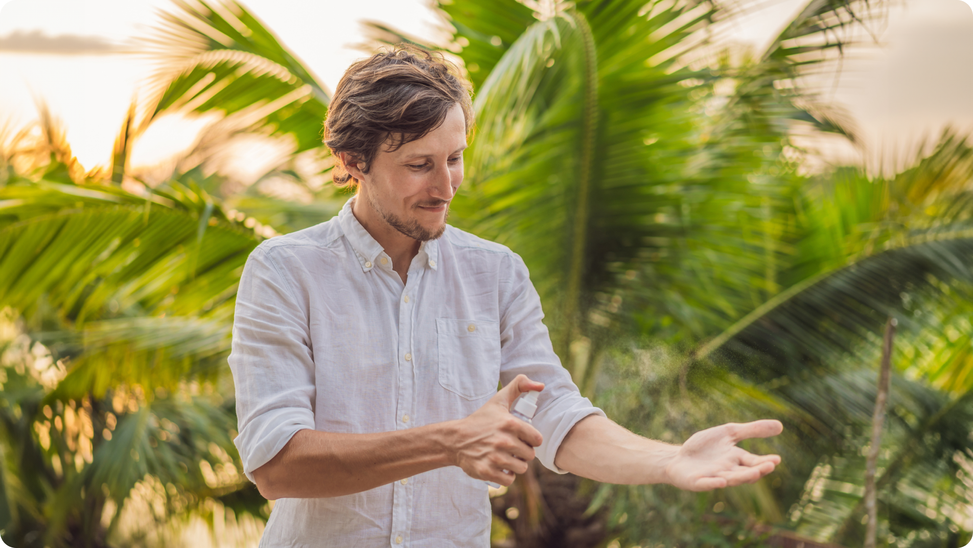 Man spraying DEET bug spray to prevent Malaria while traveling in the tropics